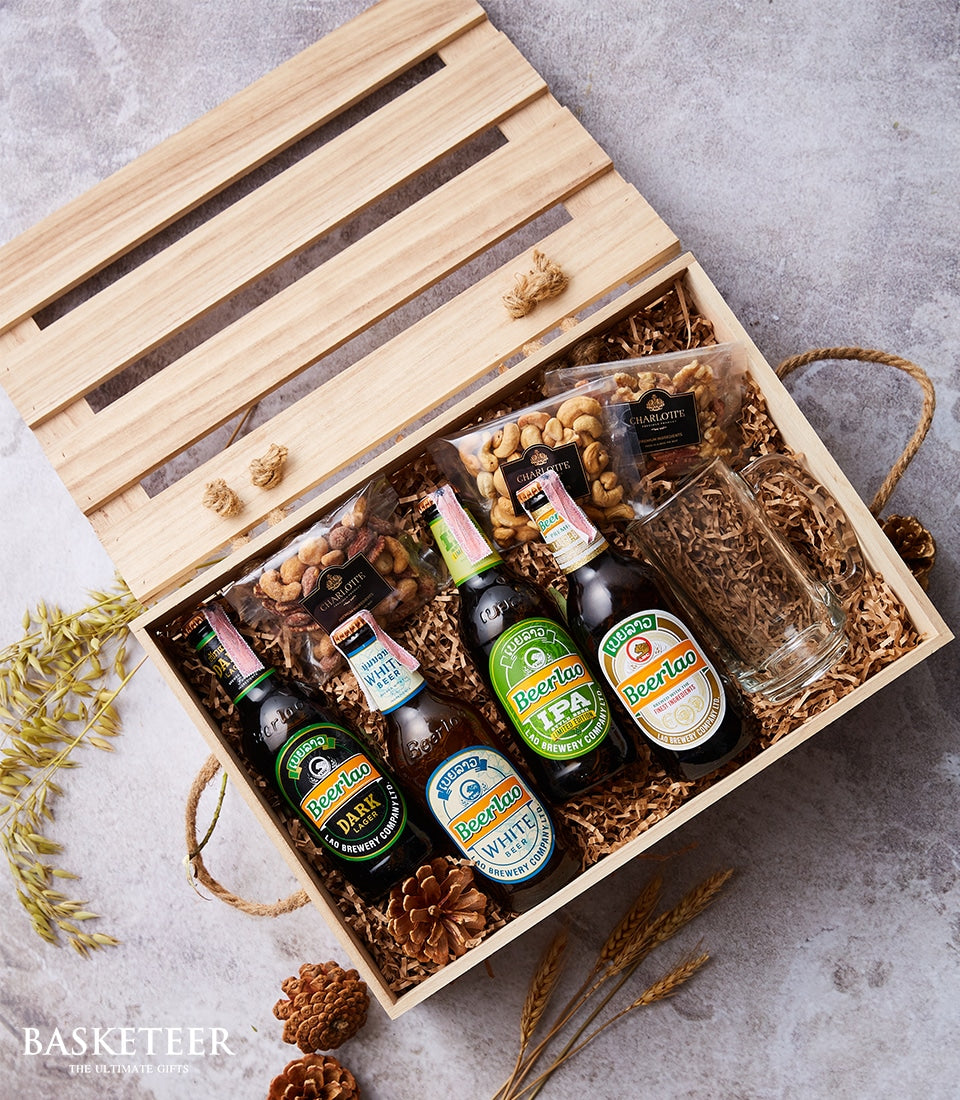 Beerlao Deluxe craft beer selection with roasted beans in wooden gift crate, grey background