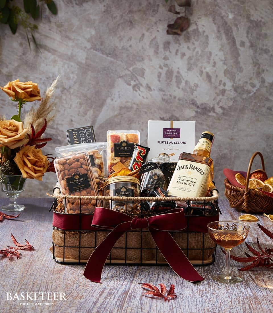 Premium gift basket with Jack Daniel's Honey whiskey, gourmet nuts, and artisan treats, tied with deep red satin ribbon