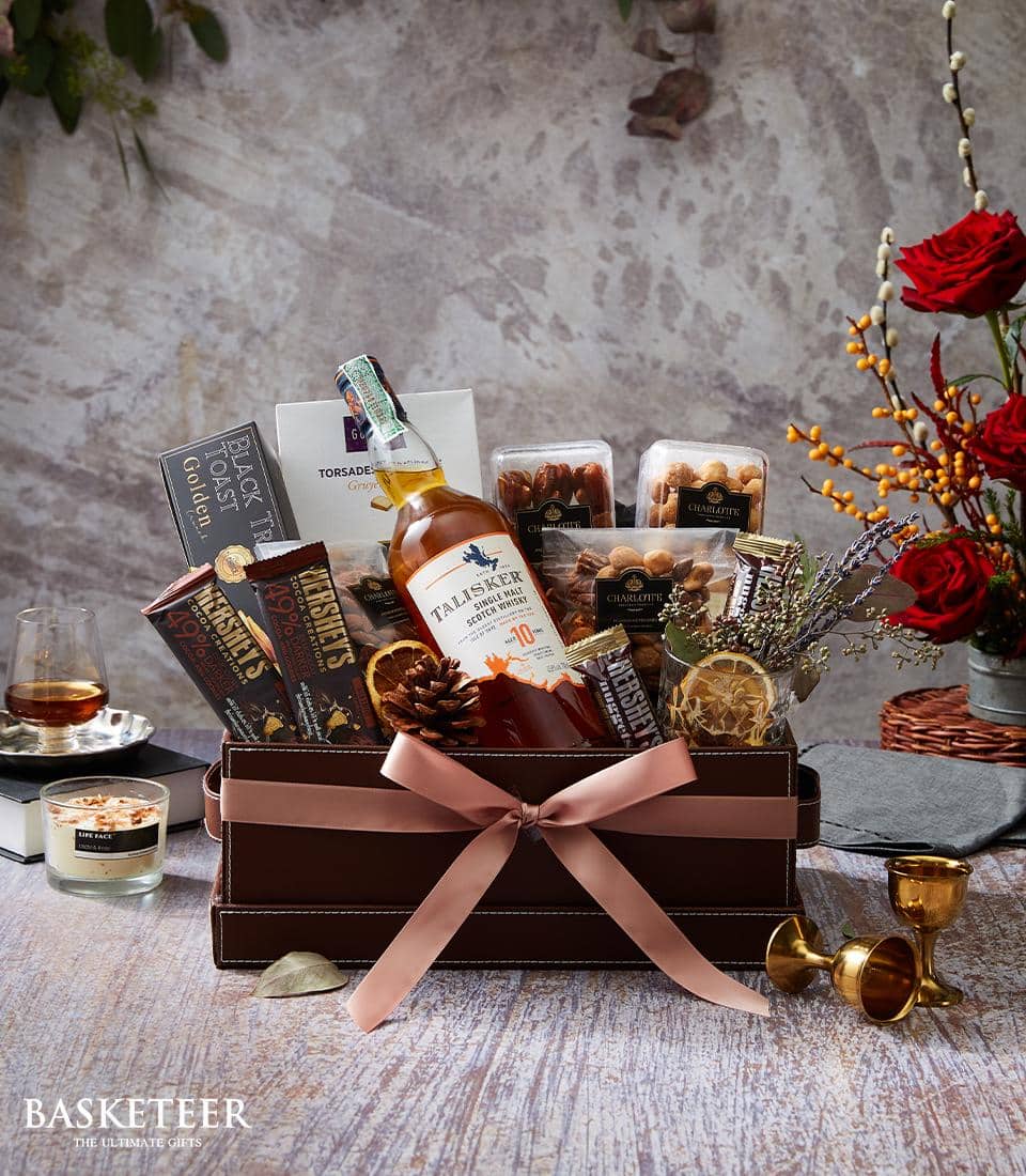 Talisker Single Malt Scotch whisky gift box with chocolate, nuts, and dried fruits in dark leather case with pink ribbon