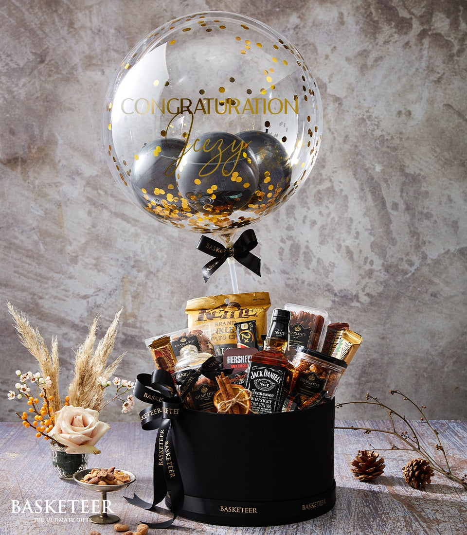 Luxury Jack Daniel's whiskey gift box with personalized gold balloon, gourmet snacks, and fresh rose arrangement