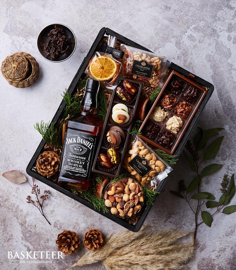 Premium whisky and gourmet nuts gift basket with Jack Daniel's, artisan chocolates, and dried citrus accents