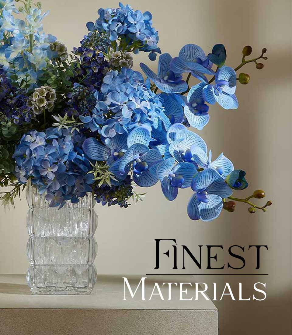 Blue hydrangea and orchid artificial flower arrangement in faceted glass vase