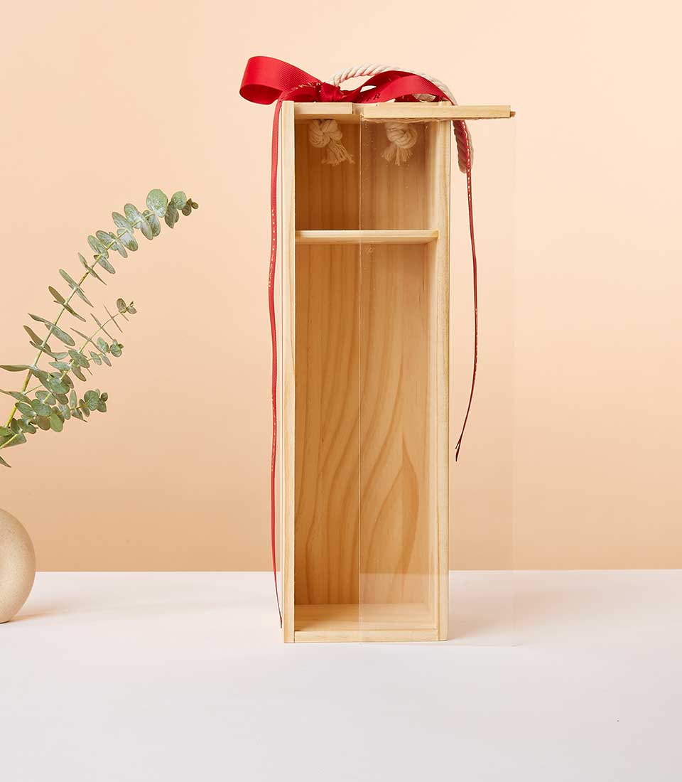 Whispering Angel rosé wine in light wood gift box with red ribbon and eucalyptus