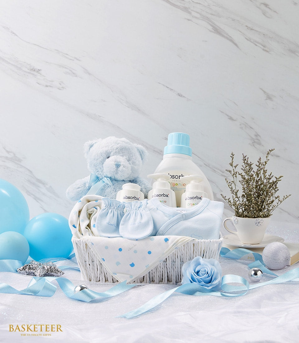 Newborn baby gift basket with soft blue teddy bear, onesie, blanket and care products