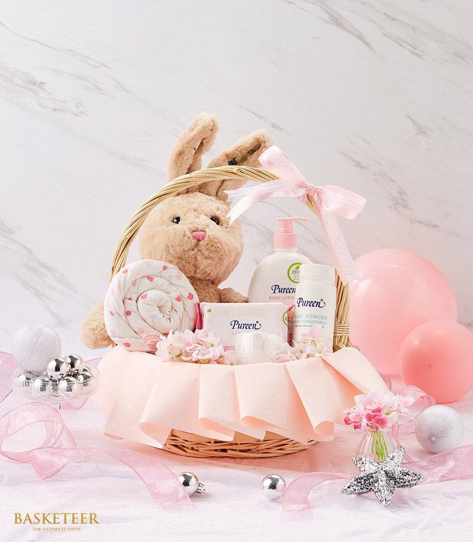Sweet pink newborn baby gift basket with plush bunny, dotted blanket, and Pureen baby care products