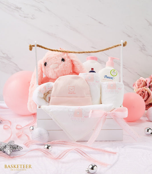 Pink newborn gift set with plush bunny, personalised hat, baby essentials in white wooden crate with pink ribbon