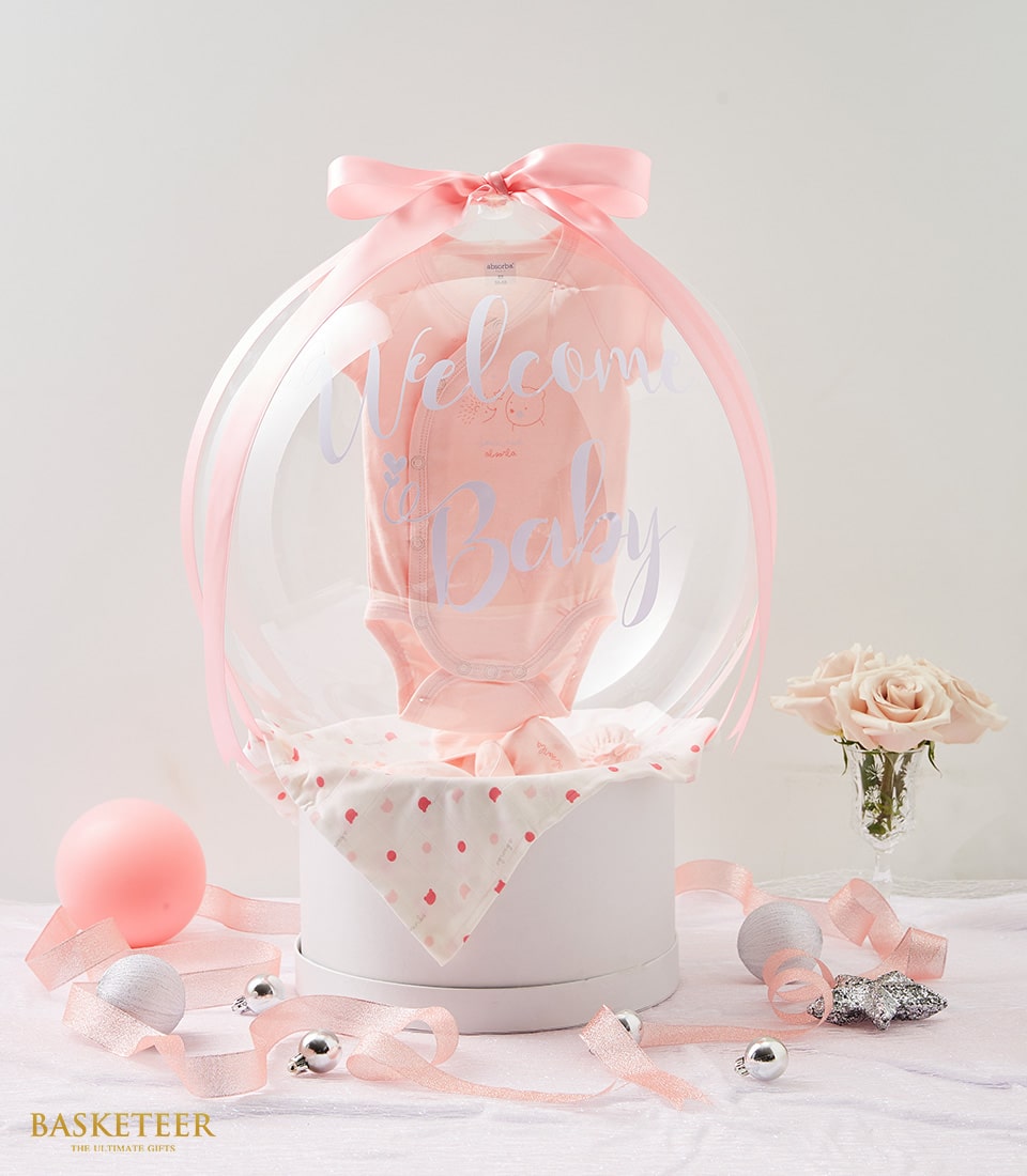 Pink and white newborn gift set with welcome baby balloon, onesie, roses and ribbon accents