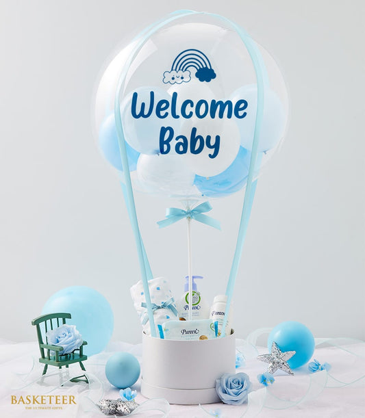 Welcome Baby hot air balloon gift set with white and blue balloons, baby care products, and blanket