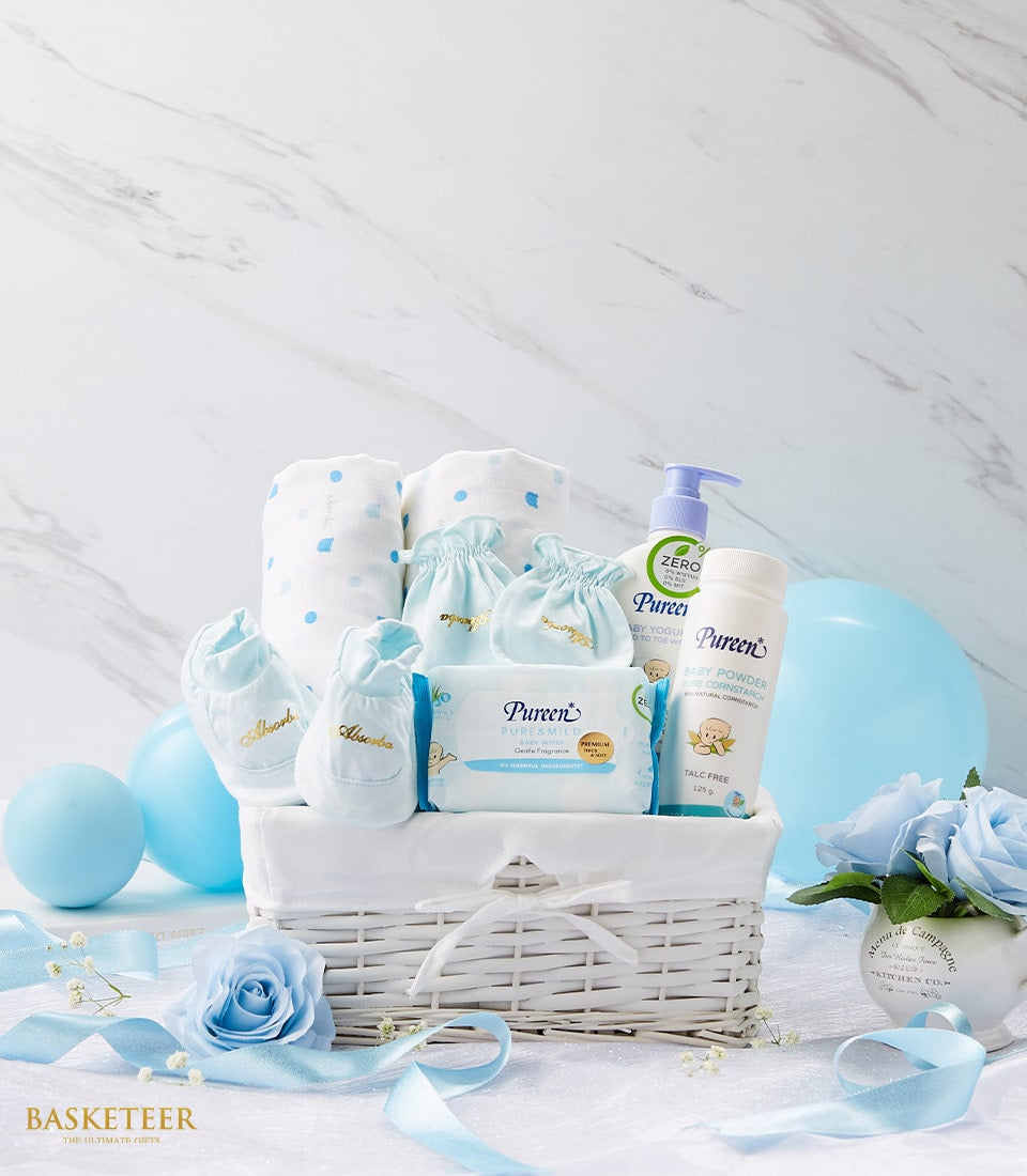 Newborn baby gift basket with blue and white essentials, blankets, booties, and lotions for new parents