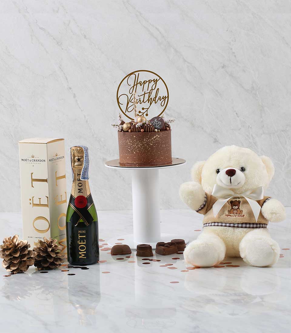 Luxury chocolate cake with champagne and teddy bear birthday gift set on marble