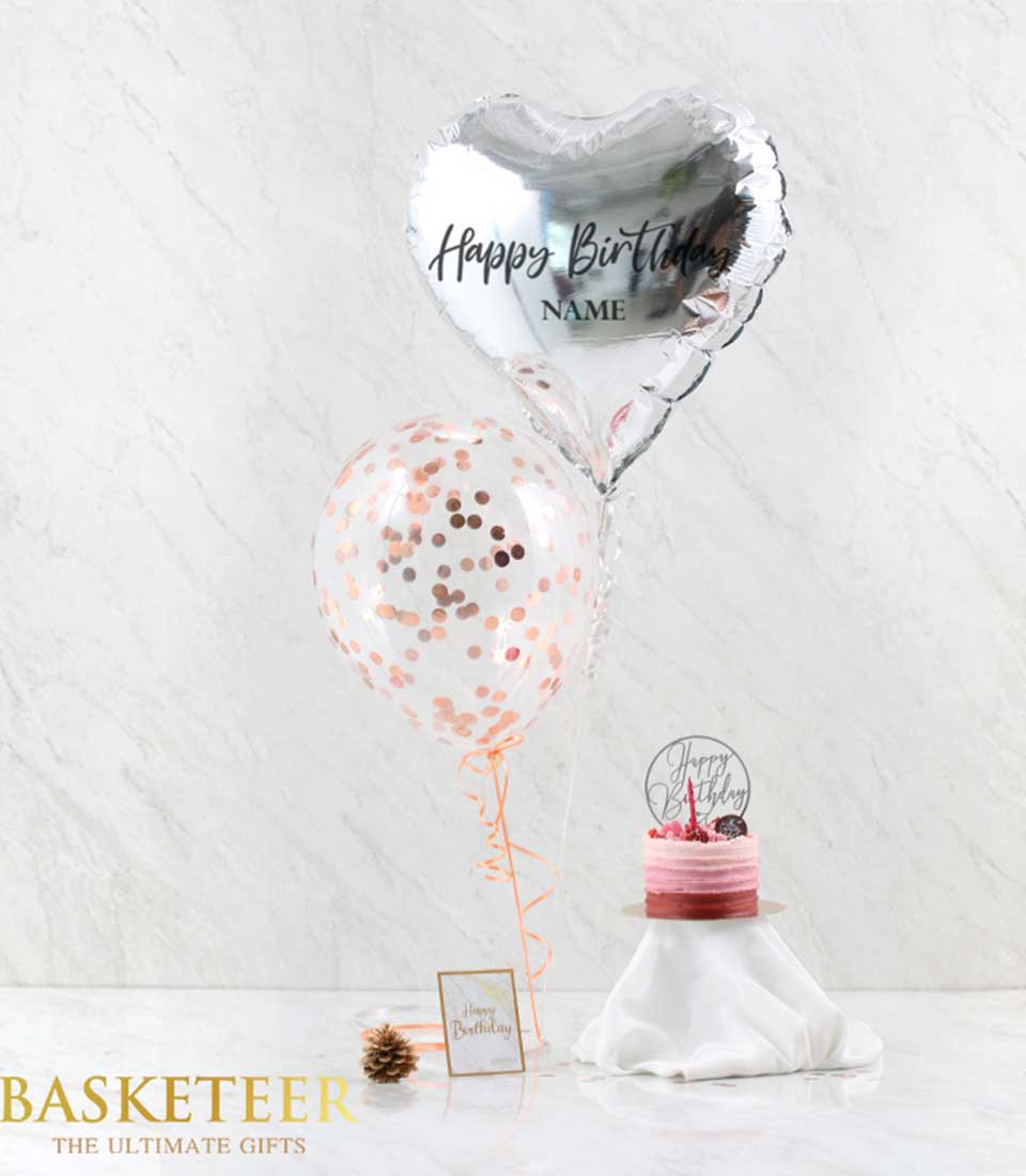 Gray heart balloon with rose gold confetti, pink tiered birthday cake, and greeting card gift set