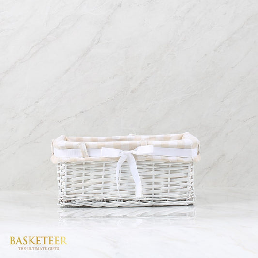 White wicker basket with plaid fabric liner and satin ribbon bow, elegant gift hamper
