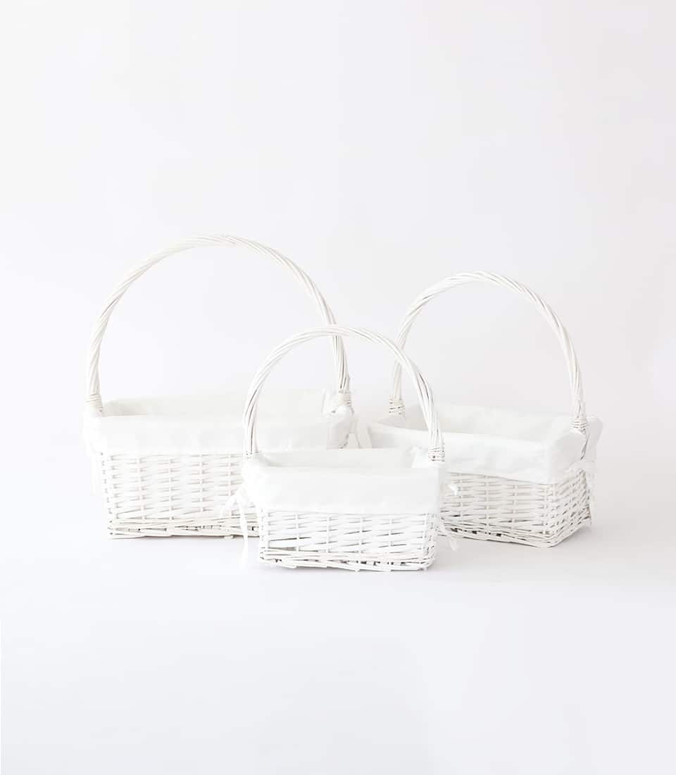 Three nested white wicker baskets with fabric liners and arched handles for premium gift presentation