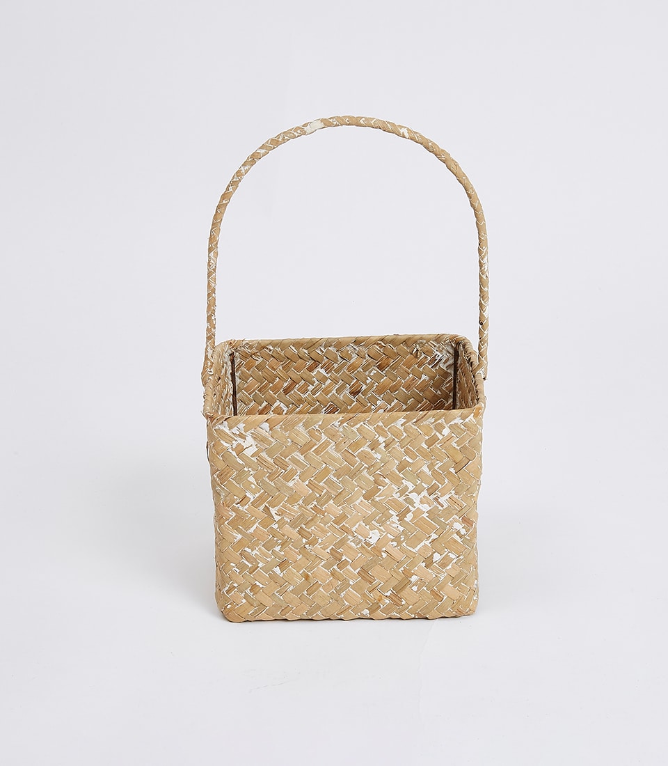 Natural woven rattan storage basket with white distressed finish and arched handle