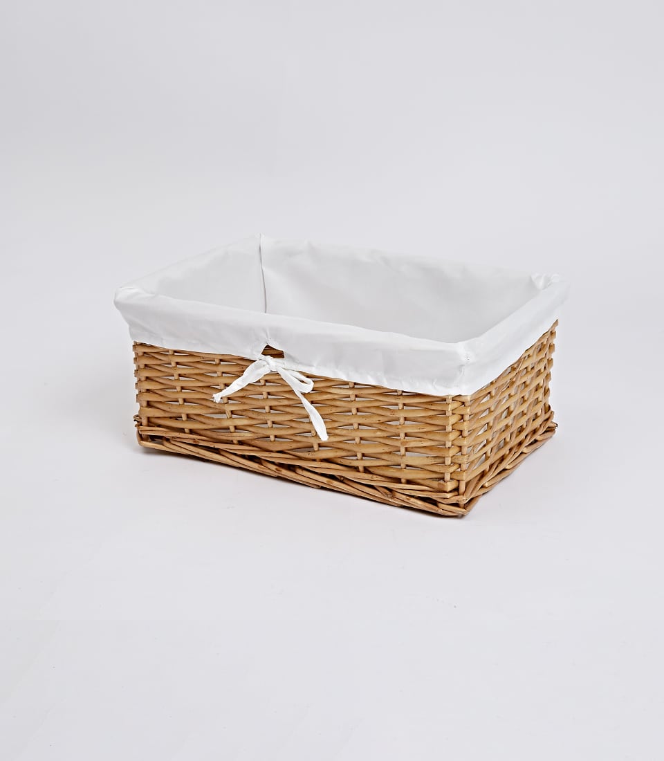 Light brown woven wicker basket with white fabric liner and ribbon bow, ready for custom gift filling