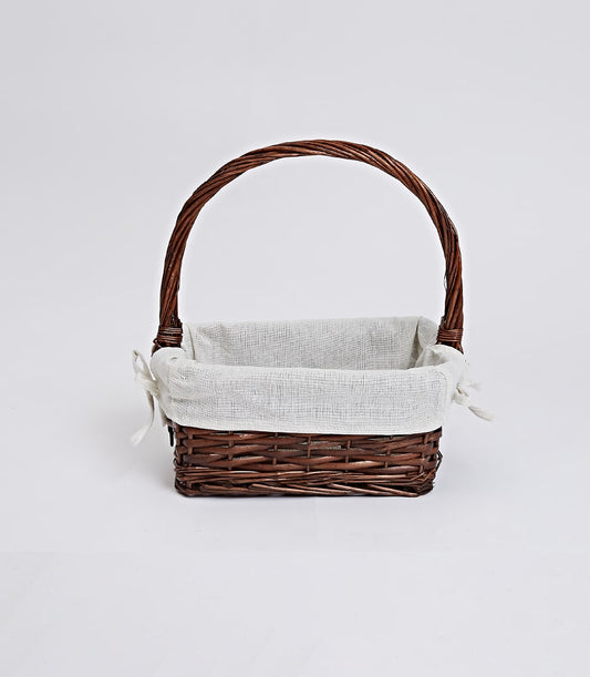 Dark brown wicker gift basket with arched handle and removable cream linen liner