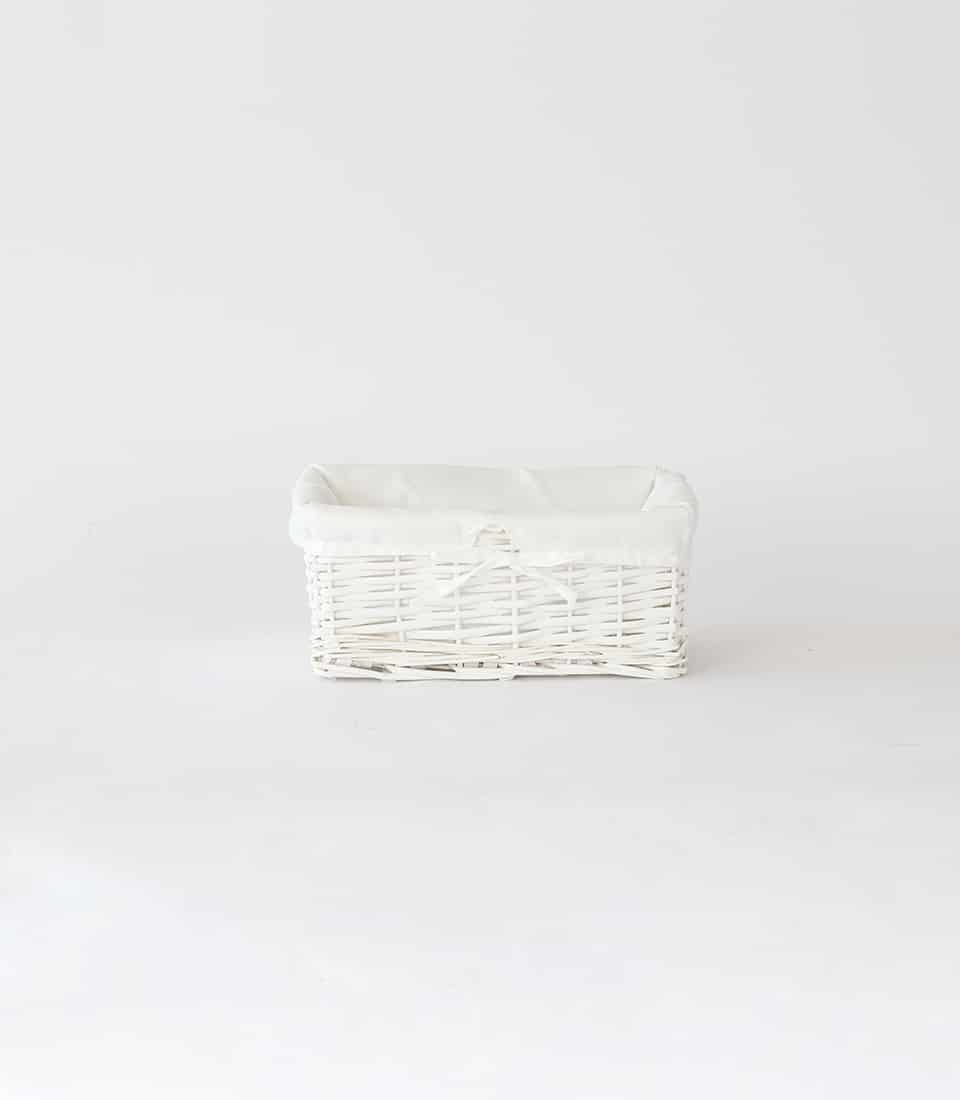White wicker gift basket with soft fabric liner and ribbon bow