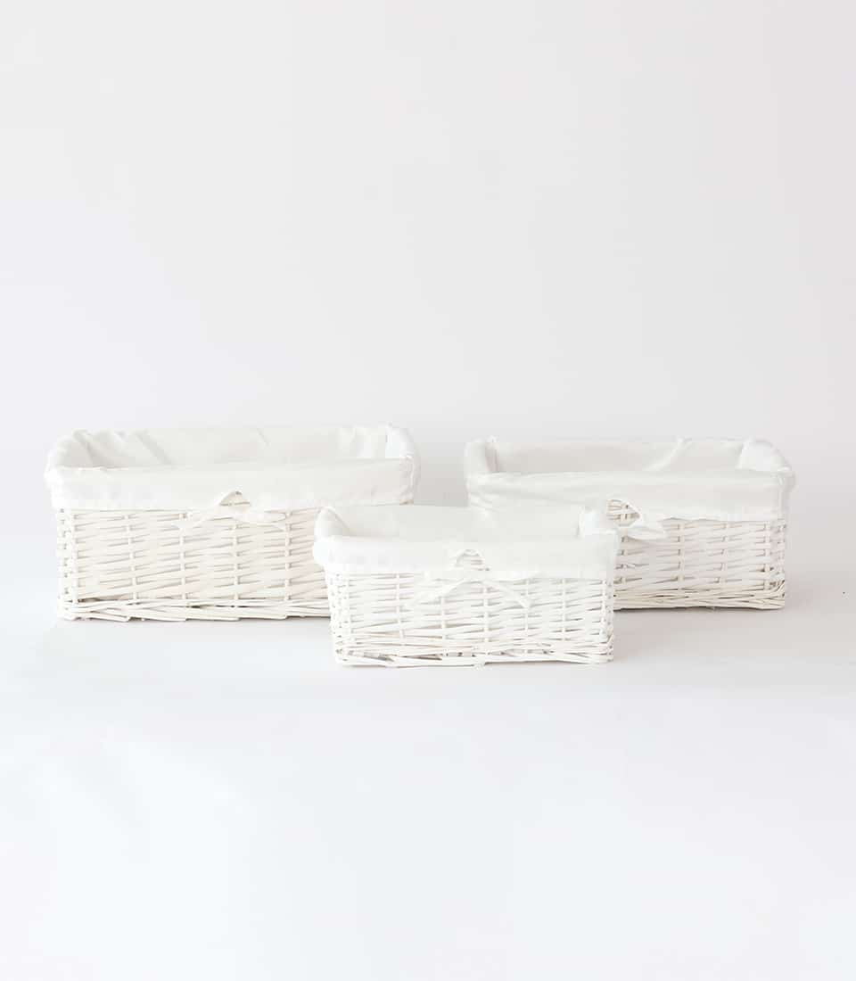 White wicker gift baskets with removable fabric liners in three sizes