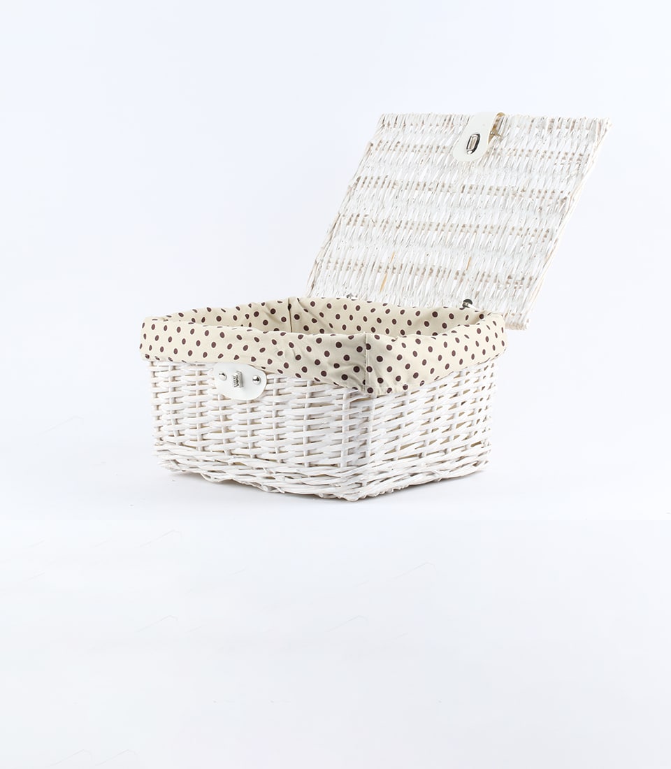 White wicker gift basket with polka-dot linen lining and metal clasp, ready to fill