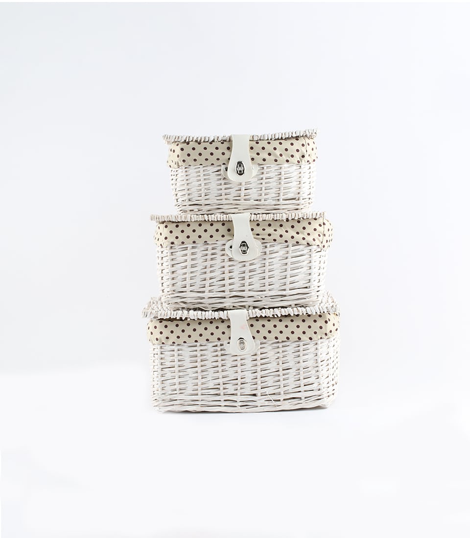 White wicker gift baskets with polka-dot lining and leather straps, stacked in three sizes