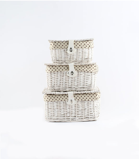 White wicker gift baskets with polka-dot lining and leather straps, stacked in three sizes