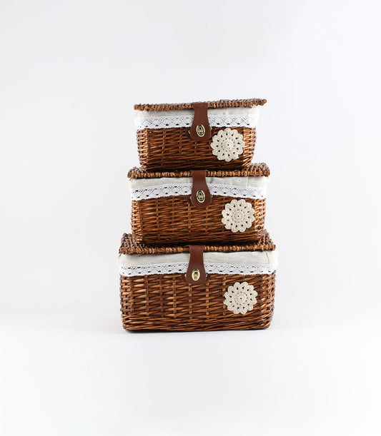 Tiered wicker baskets with white lace liners, leather straps, and crocheted floral details for luxury gift hampers
