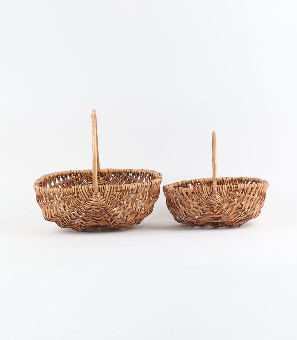 Rustic brown wicker baskets with curved handles, crafted for premium gift presentation