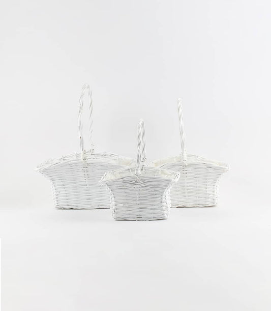 Three white wicker gift baskets with twisted handles, arranged by size for luxury hamper curation