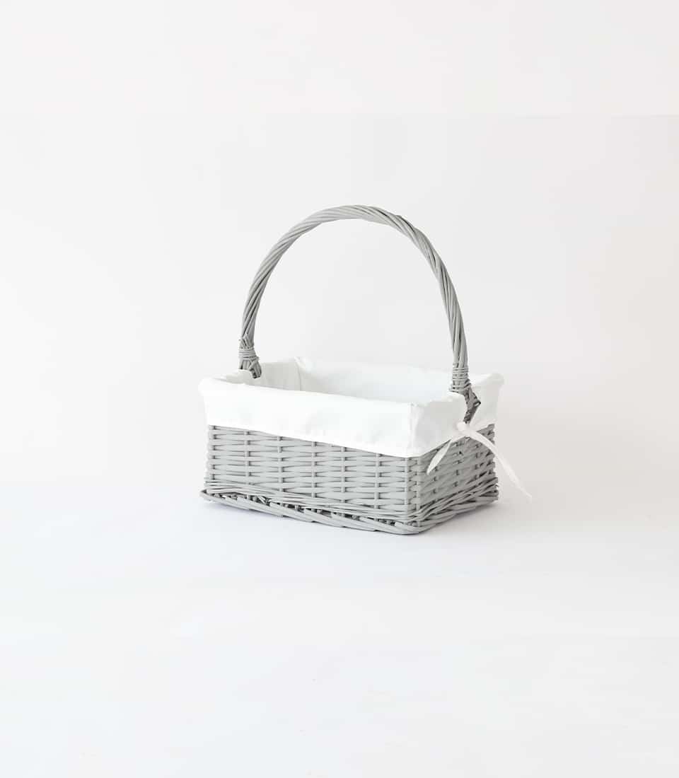 Light gray wicker gift basket with white fabric lining and bow detail
