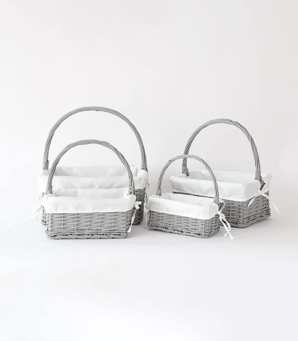 Nested grey wicker baskets with white fabric liners and arched handles, set of four graduated sizes