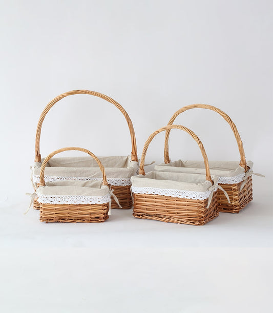 Light brown wicker baskets with arched handles and removable lace-trimmed liners, four-piece set for custom gift hampers