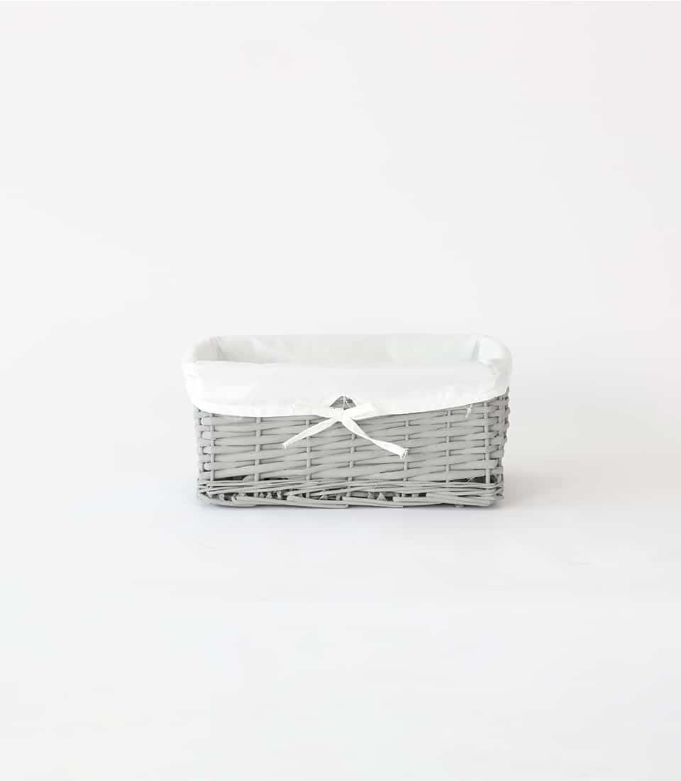 Light grey wicker basket with white fabric liner and ribbon bow, ready for gifting