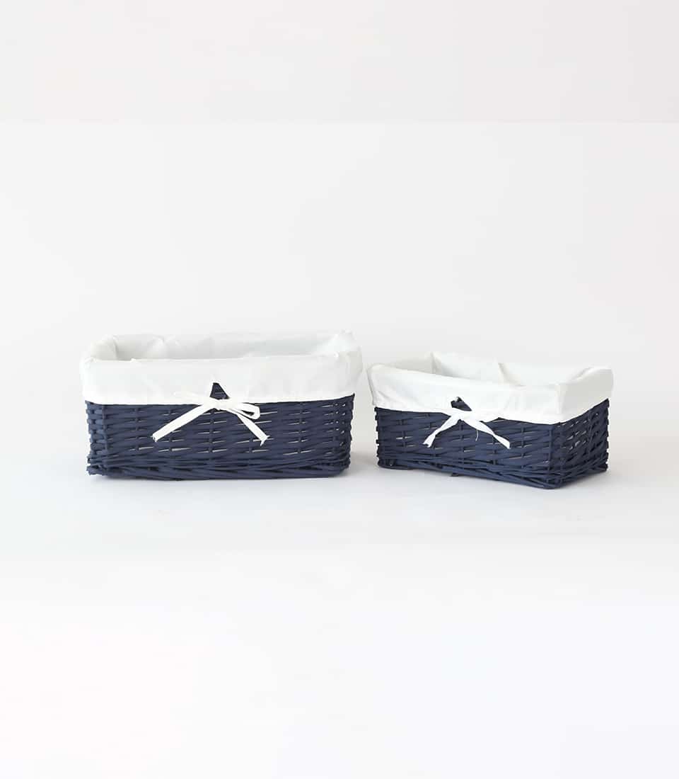 Navy blue rattan storage baskets with white fabric liners and ribbon bows