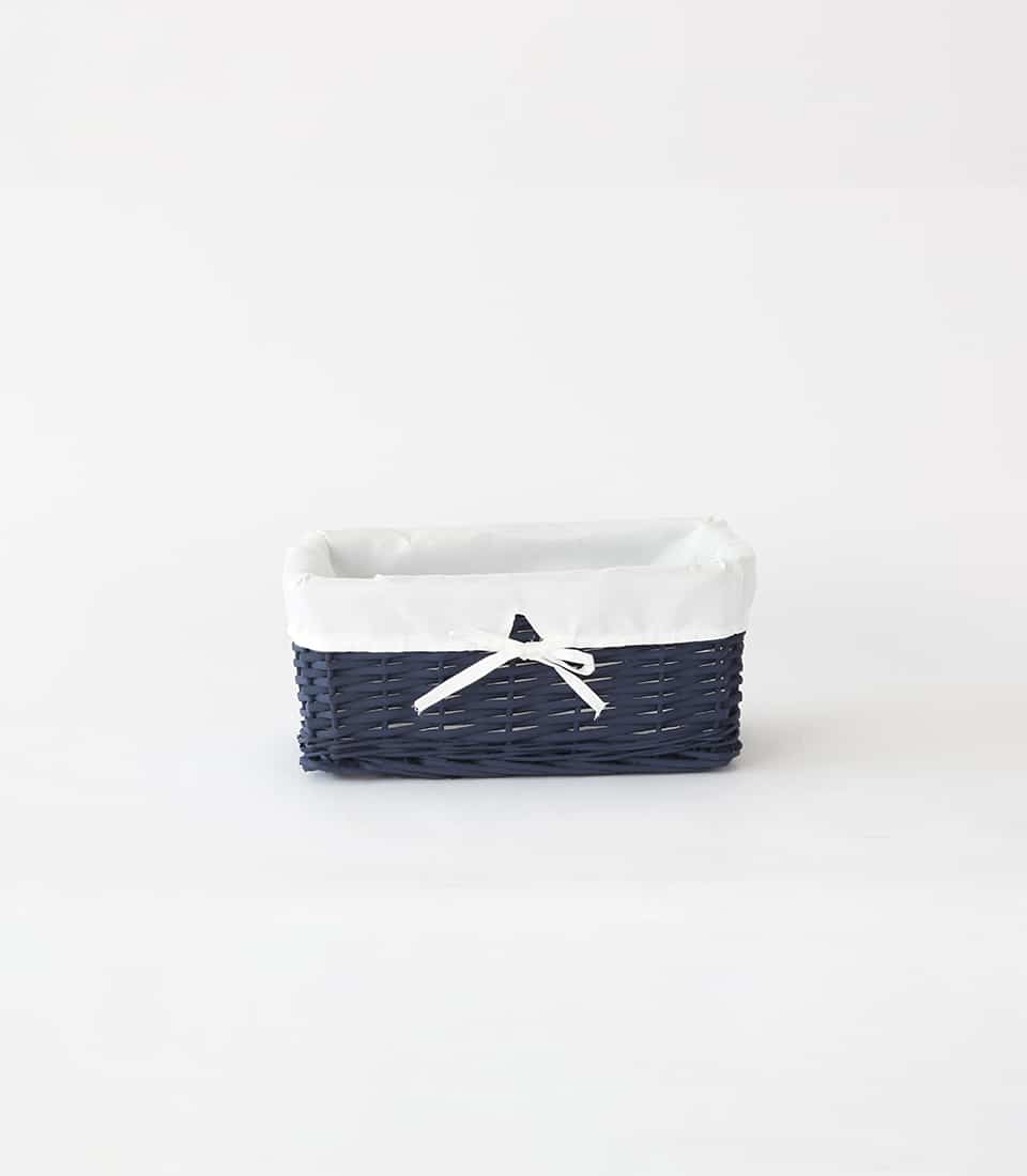 Navy blue woven rattan basket with white cloth liner and bow detail
