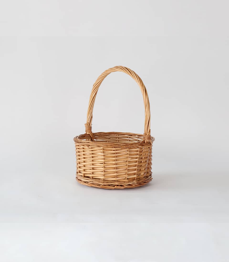 Light brown wicker hamper with arched handle, handcrafted for premium gift presentations