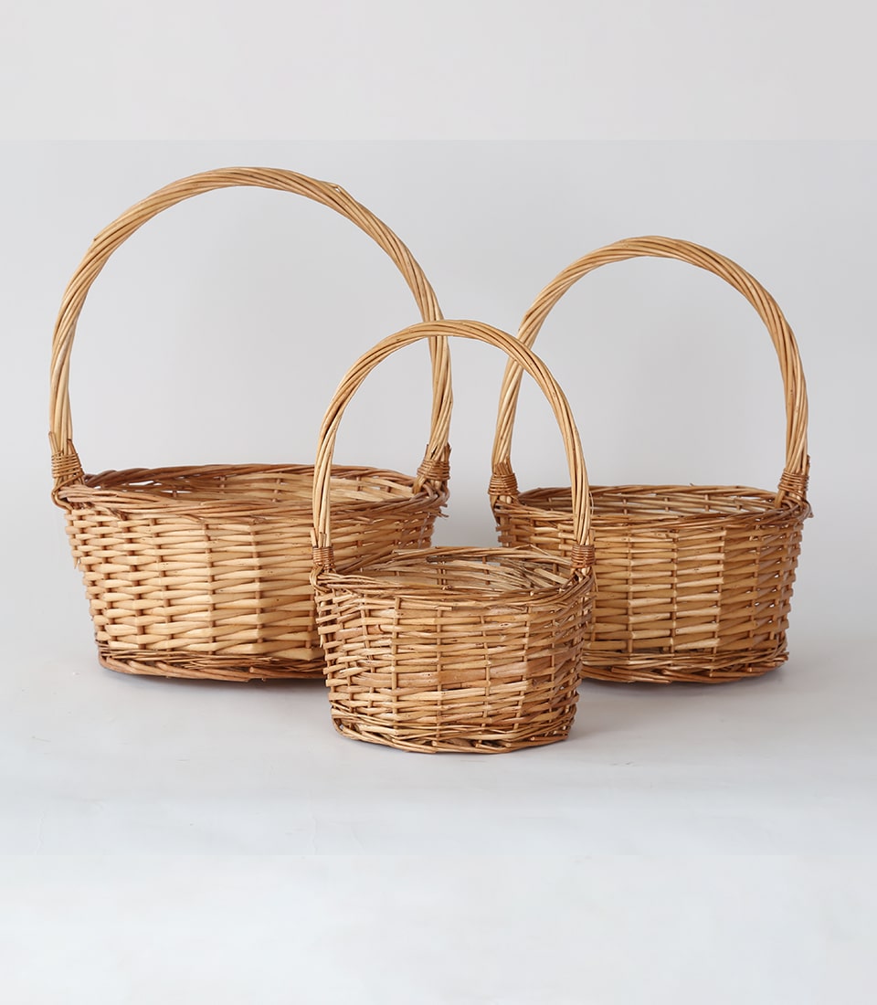 Hand-woven natural wicker hamper baskets with arched handles in three sizes
