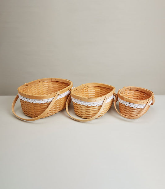Nested woven wood baskets with white lace trim and curved handles, three sizes for elegant gift presentation
