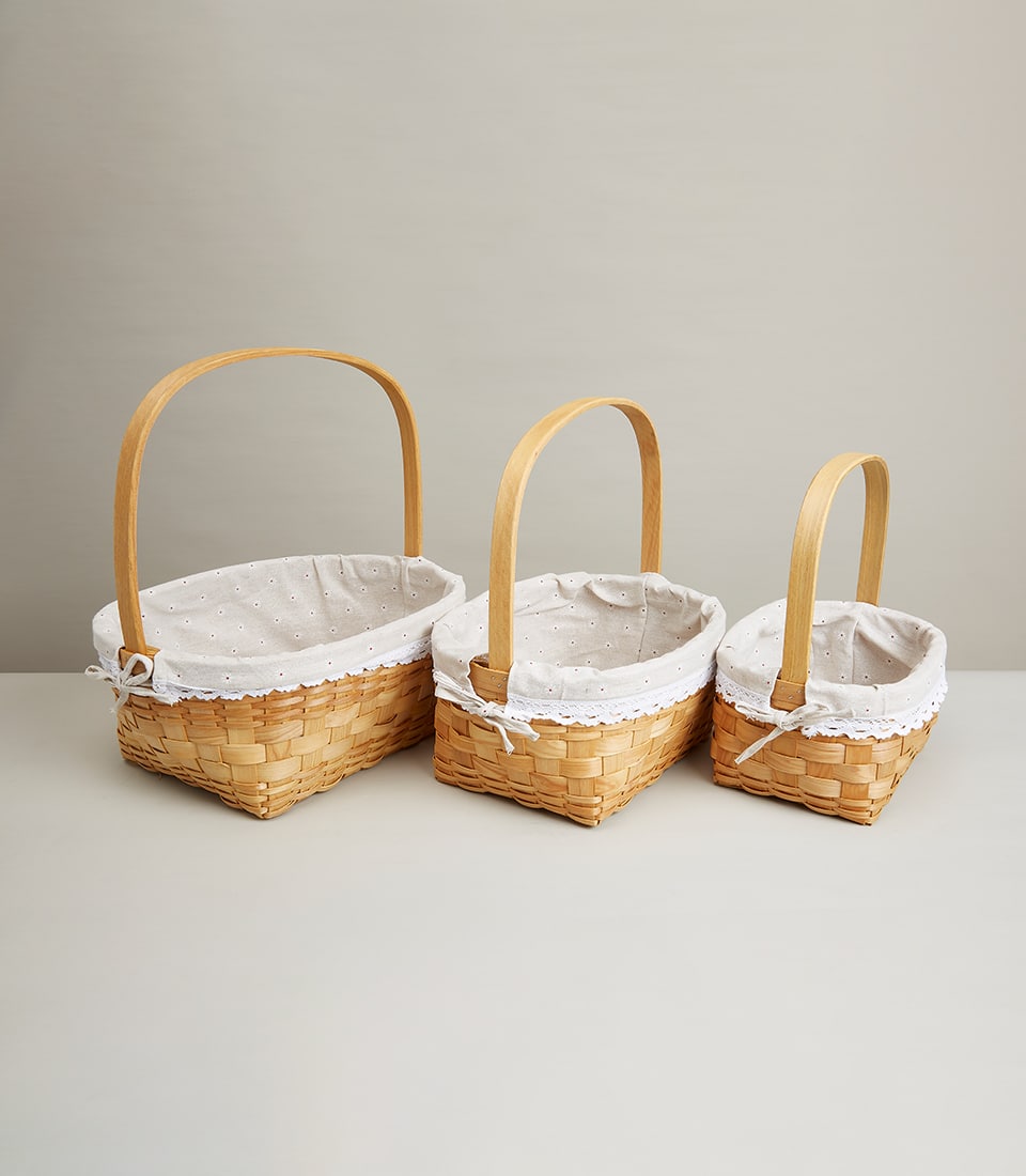 Nested woven rattan baskets with beige polka-dot fabric linings and white lace trim