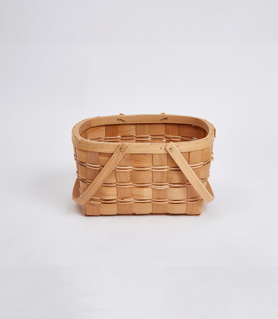 Light brown woven wicker basket with wooden handles, ready for custom gift curation