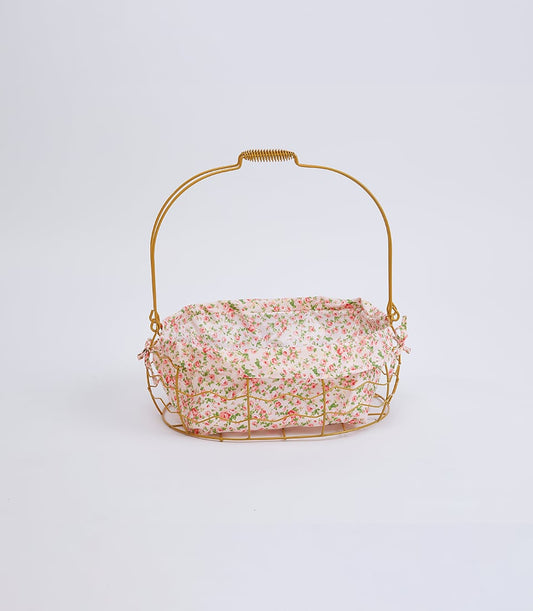 Golden wire basket with floral fabric liner and arched handle, perfect for gift presentation