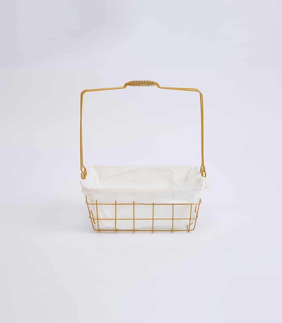 Gold wire basket with white fabric liner and coiled handle, minimalist design for gifting