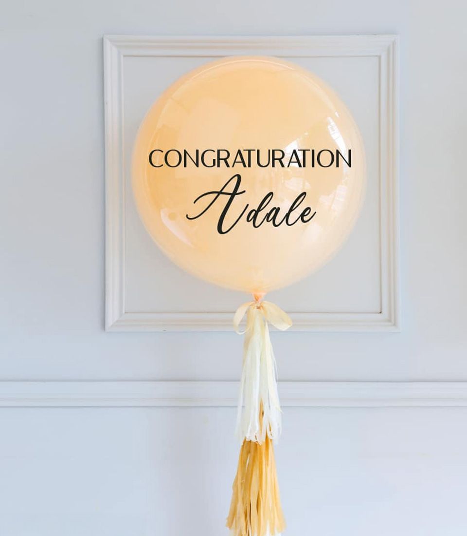 Personalised peach congratulations balloon with cream tassel and custom name in script