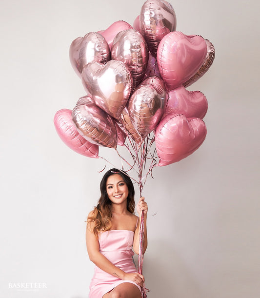 Rose gold heart-shaped balloons bouquet with metallic pink foil balloons and ribbon ties for birthday celebrations