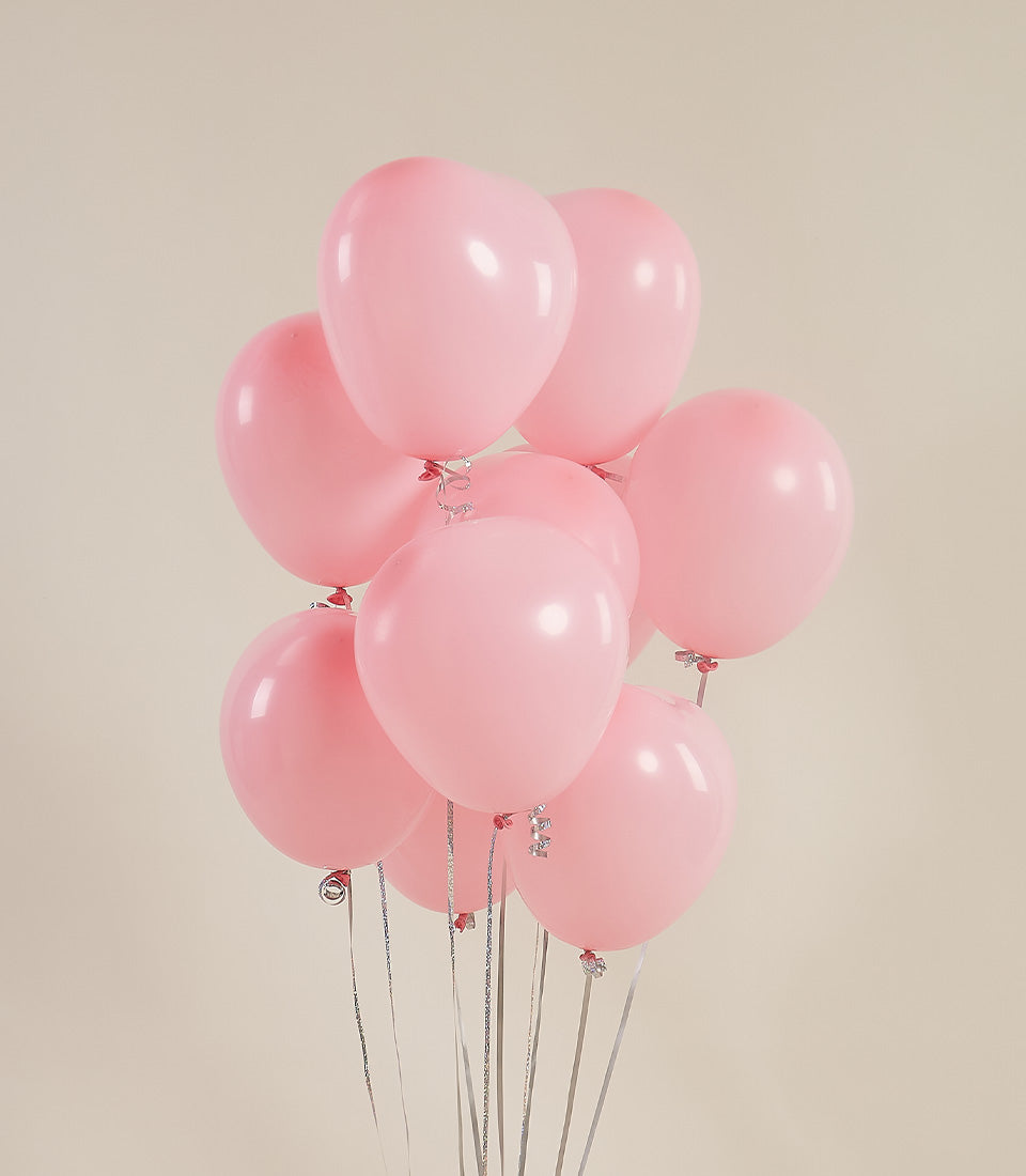 Pastel pink heart balloons with silver ribbons for romantic celebrations