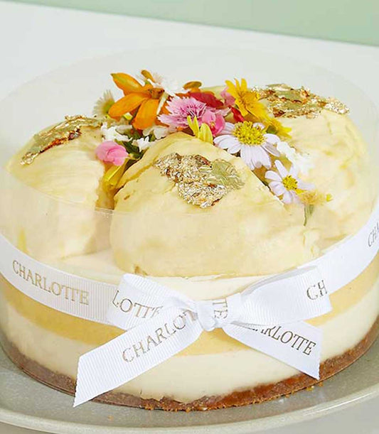 Royal Durian Crown layered cheesecake with gold leaf, fresh flowers, and creamy mousse topping in gift box