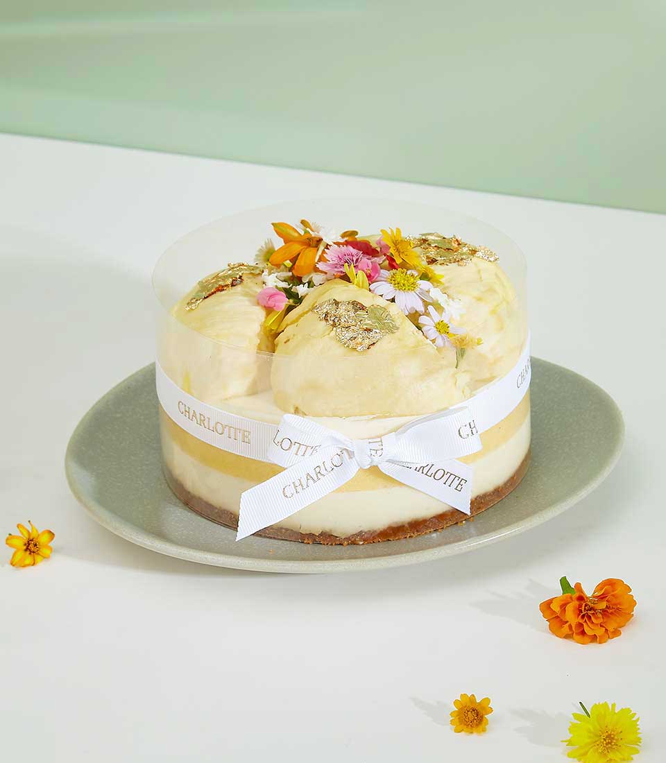 Royal Durian Crown cheesecake with gold leaf and fresh flowers, luxury celebration cake by Charlotte Bakery