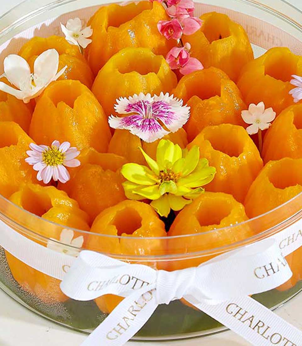 Peeled Mayongchid tropical fruits gift box with white ribbon and colorful flowers