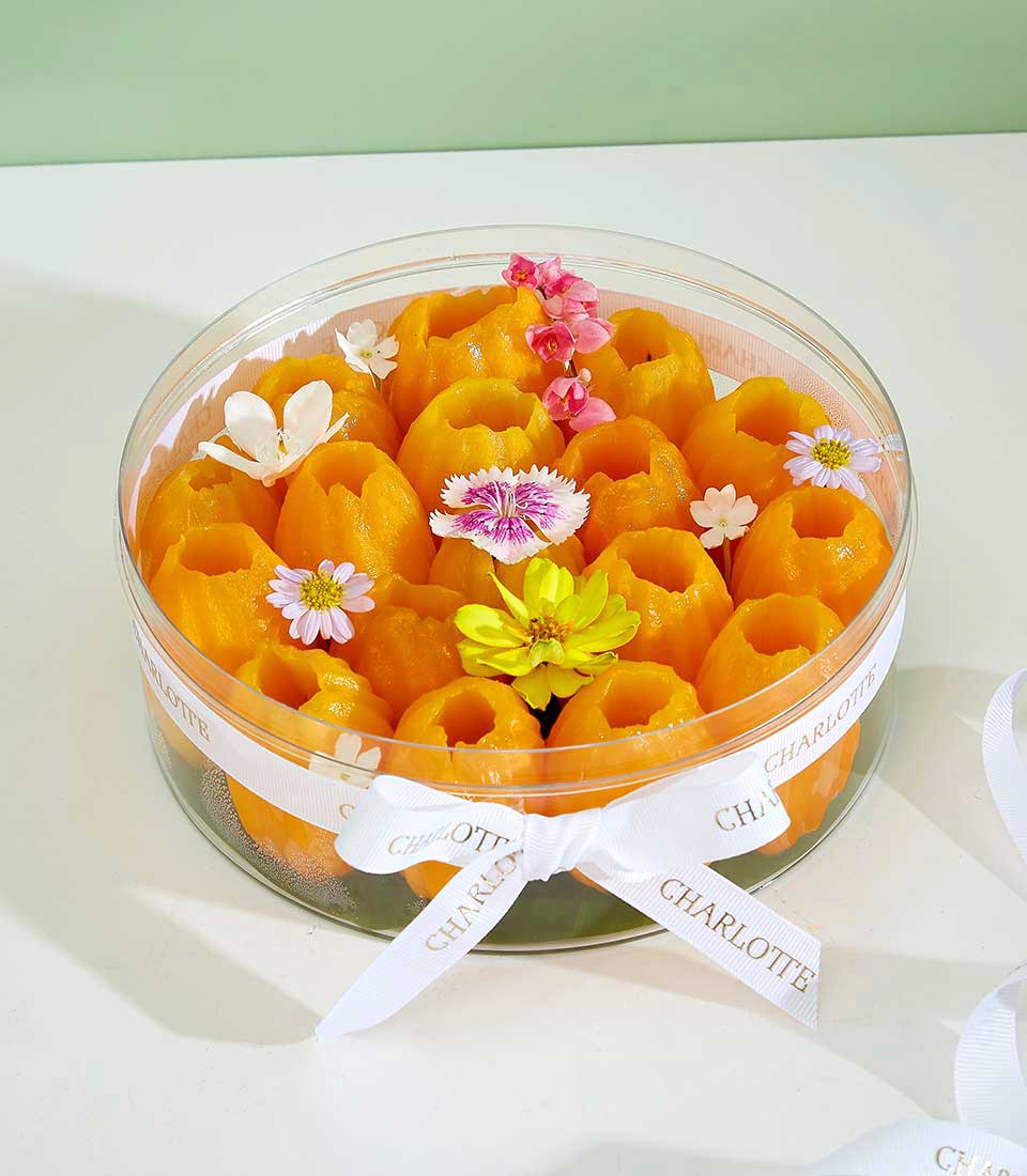 Dried mayongchid tropical fruit selection in clear gift container with white ribbon and decorative flowers