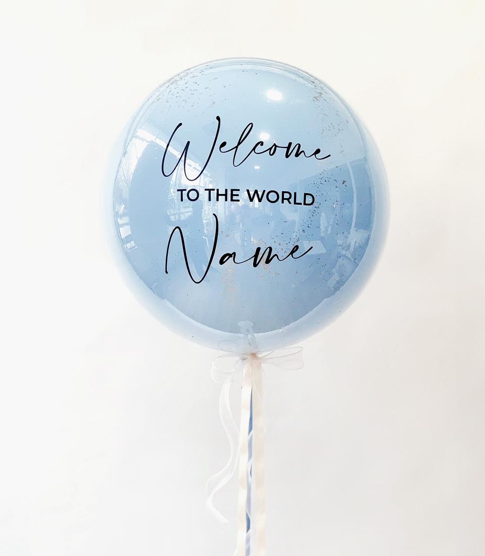 Light blue welcome balloon with "Welcome to the World" text and personalized name, filled with confetti for new baby
