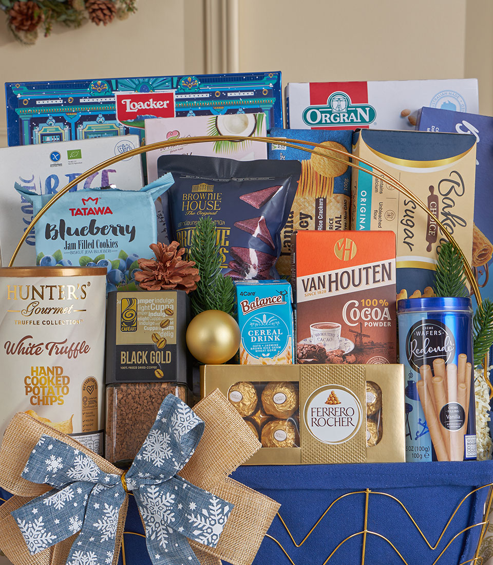 Blue fabric gourmet gift basket with truffle chips, freeze-dried coffee, Ferrero Rocher, and festive snowflake ribbon for